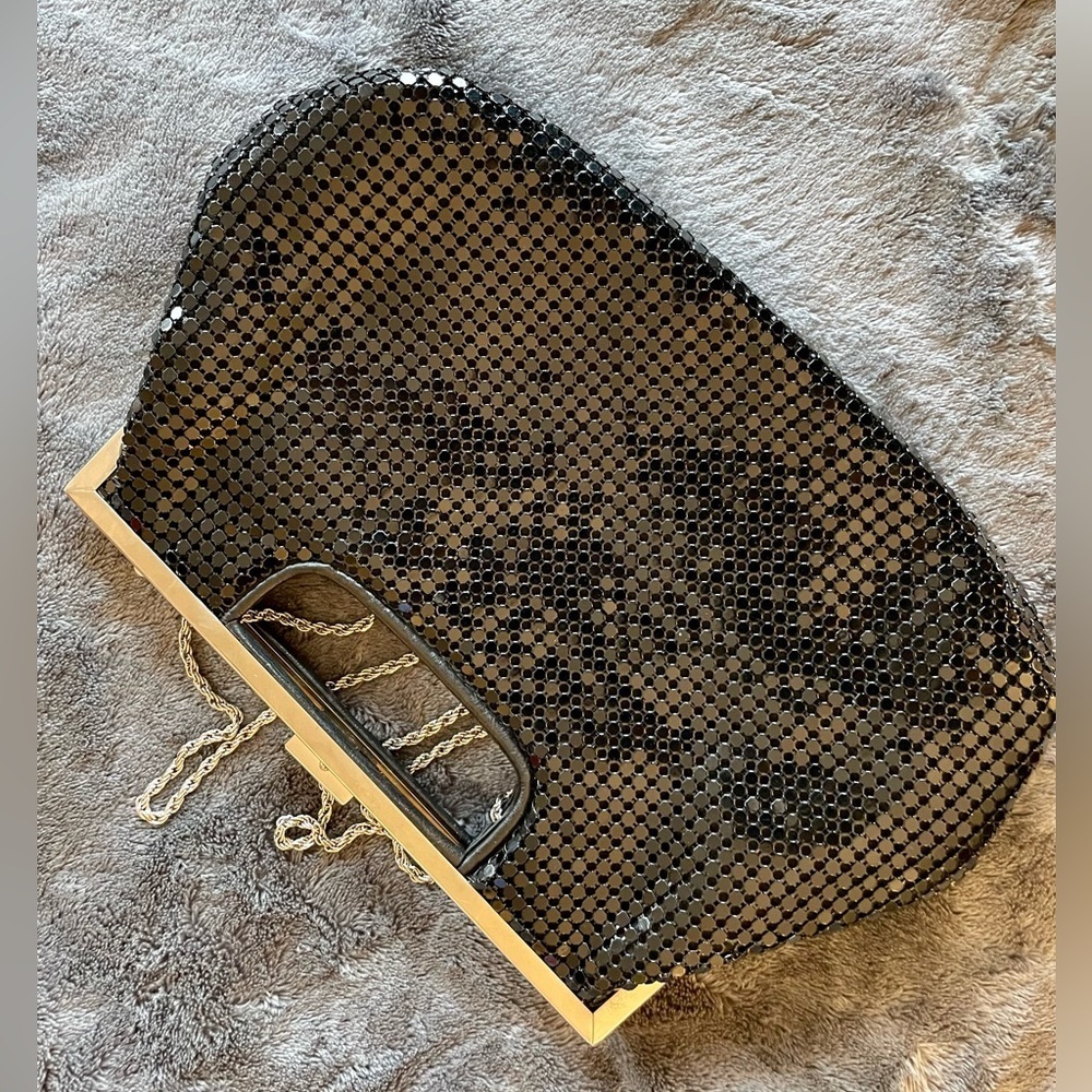 Cute clutch or shoulder bag in shiny black with a metallic strap